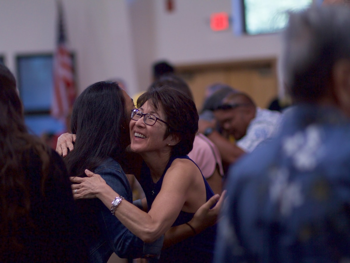 Two members of a congregation embracing after a service